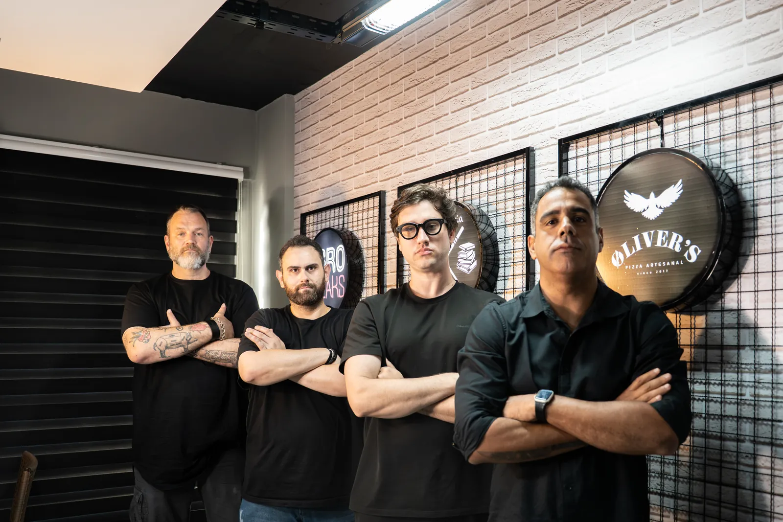 Sócios do Grupo Rob Food reunidos no escritório da holding, com as marcas do grupo ao fundo